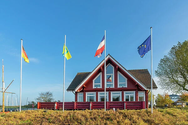 Flags waving in front of Rendez Vous restaurant in Niendorf harbor, Niendorf, Timmendorfer Strand, Ostholstein, Schleswig-Holstein, Germany