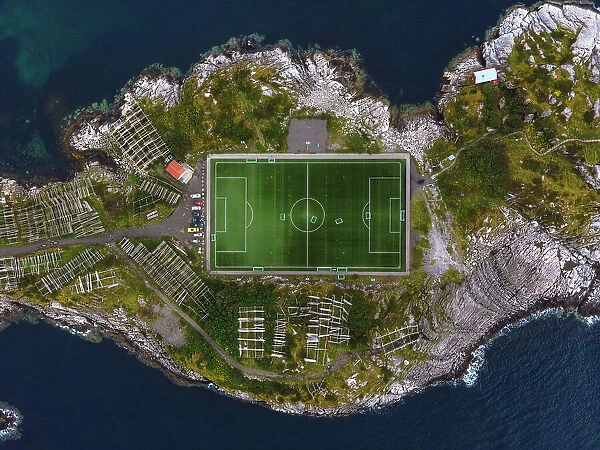The football field of Henningsvaer framed by the rocks of the coast. Lofoten Islands, Norway