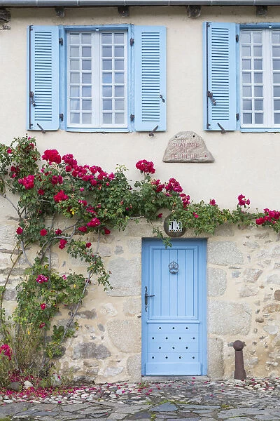 France, Correze, Argentat, A colourful facade of an old stone house with blue shutters