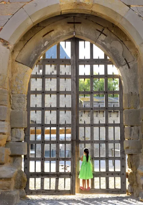 Framed Print : France, Languedoc, Carcassonne, Girl looking through castle gate (MR) Framed Print : France, Languedoc, Carcassonne, Girl looking through castle gate (MR)