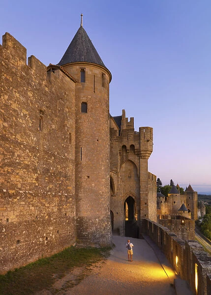 France, Languedoc, Carcassonne, man taking photograph from walls at dusk (MR)