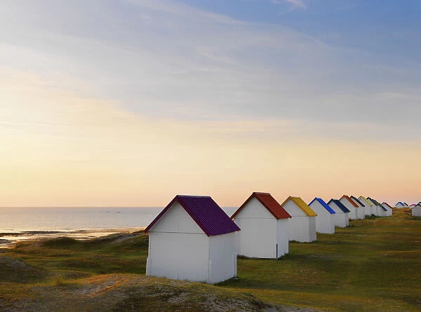 France, Normandy, Gouville Sur Mer, colourful beach huts at dusk