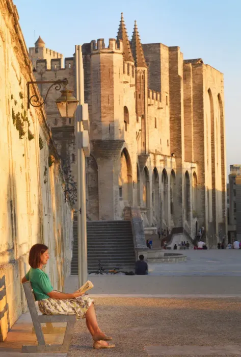 Framed Print : France, Provence, Avignon, Palais de Papes, Woman reading book on bench MR