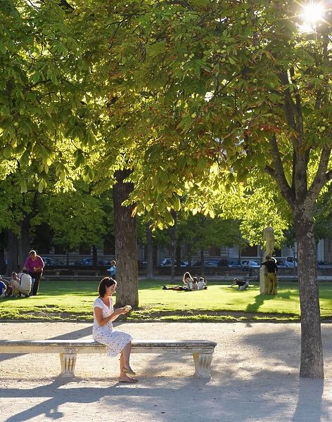 France, Provence, Nimes, Les Jardins de la Fontaine, Woman reading in park MR