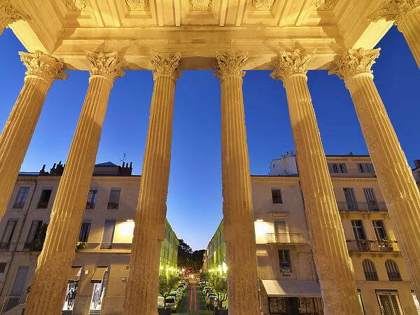France, Provence, Nimes, Maison Caree, View through pillars at night