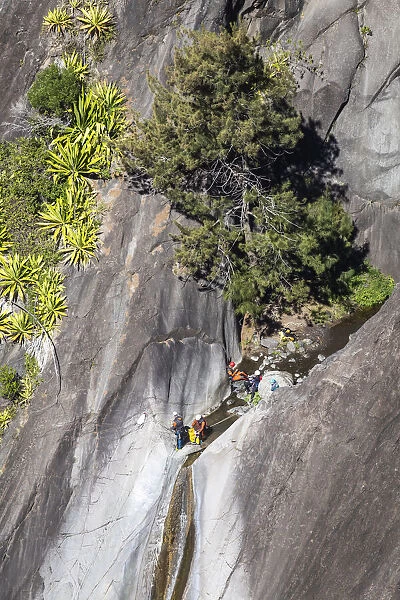 France, Reunion Island, Cirque du Cilaos, Hikers descending a rocky wall nearby Cilaos
