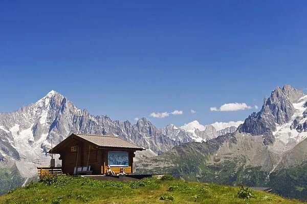 France, Rhone Alps, Chamonix Valley, hikers resting at a mountain hut with Les Dru mountains