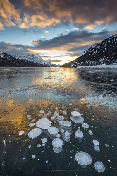 Frozen gas bubbles trapped in the ice at sunset. Silvaplana Lake, Silvaplana, Engadin