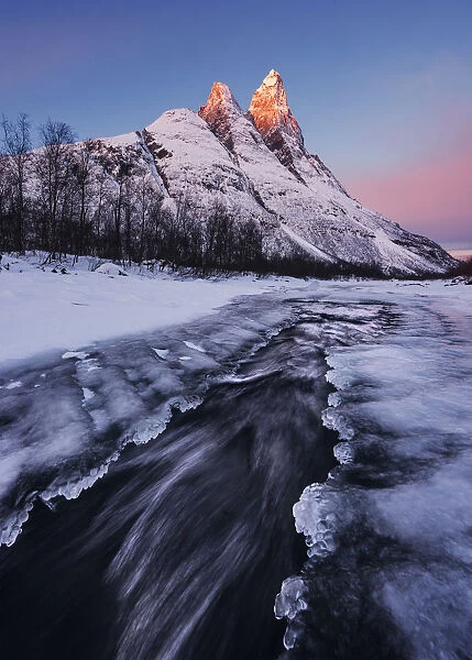 Frozen river and Mt. Otertinden taking the first lights of the day, Tromso region, Norway