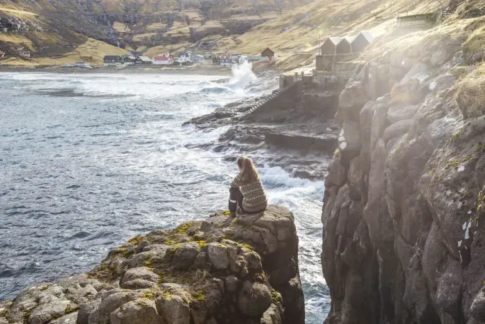Framed Print : Girl sitting along the fjord close to Tjornuvik. Streymoy island, Faroe islands Framed Print : Girl sitting along the fjord close to Tjornuvik. Streymoy island, Faroe islands