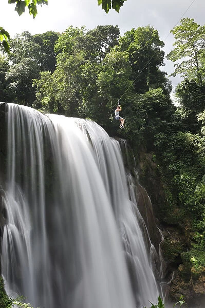 Girl on zip line over waterfall, Cascadas Pulhapanzak, Waterfalls, Honduras. MR