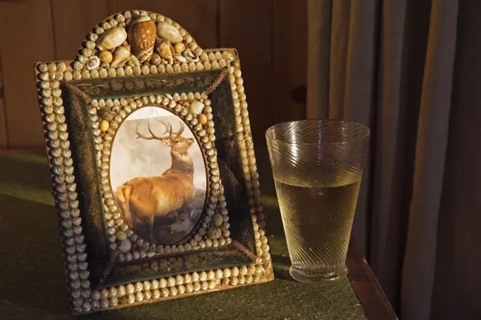 Framed Print : A glass of whisky rests beside a shell encrusted picture Framed Print : A glass of whisky rests beside a shell encrusted picture