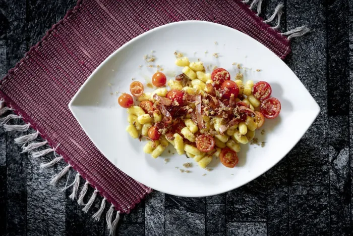 Framed Print : Gnocchi with bacon and small tomatoes on rustic placemat, Italy Framed Print : Gnocchi with bacon and small tomatoes on rustic placemat, Italy