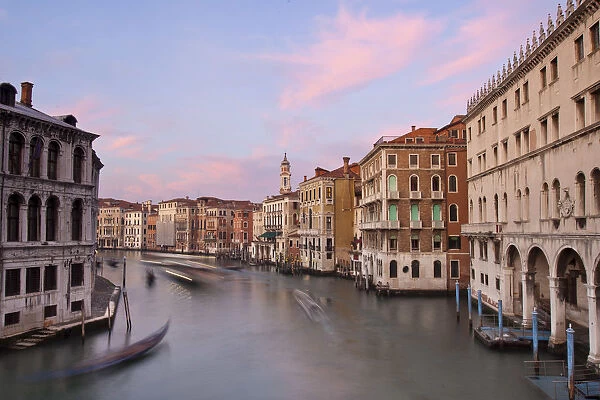 Gondolas gliding along Canal Grande at sunset - Venice, Italy