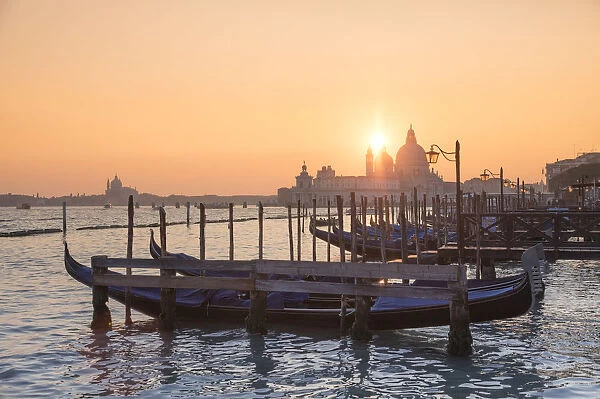 The Grand Canal with Gondolas dock, lamp post and Basilica of Saint Mary of Health at sunset