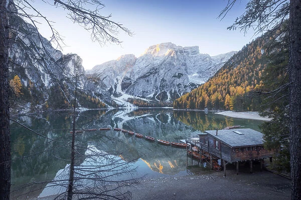 The grand view of the lonely cabin on the Braies lake (Pragser Wildsee) during a calm autumn morning. Dolomites, Italy