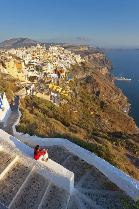 Framed Print : Greece, The Cyclades, Santorini (Thira), Fira, Woman sitting on wall in town (MR)