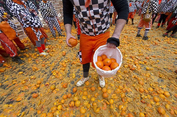 Guys pick oranges from the ground to prepare the next attack