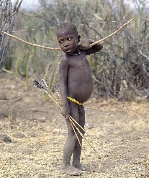 A Hadza boy carrying a bow and arrows