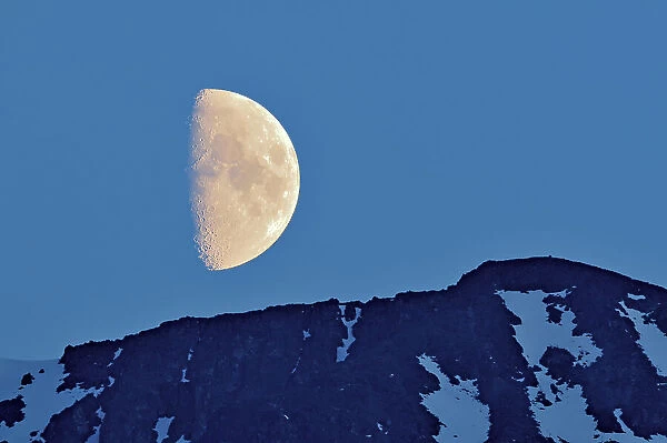 Half moon rising above mountain Stewart Cassiar Highway, British Columbia, Canada