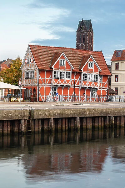 Half-timbered building called Gewolbe (The Vault) and tower of St. Marienkirche church in background, Wismar, UNESCO, Nordwestmecklenburg, Mecklenburg-Western Pomerania, Germany