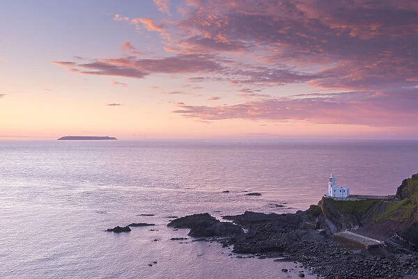 Hartland Point Lighthouse and Lundy Island beneath a colourful sunset, North Devon