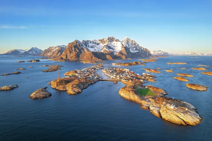Framed Print : Henningsvaer with snowy massif in the background seen from the drone at sunset, Vagan, Austvagoy, Nordland, Lofoten, Norway, Northern Europe, Scandinavia, Europe