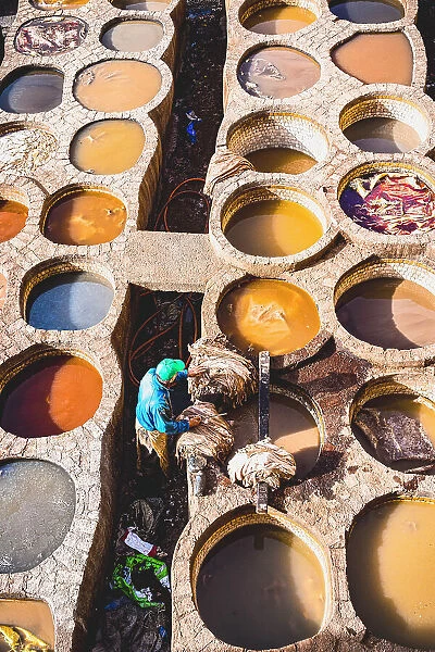 High angle view of man working at the vats of colours in the tannery of Fes, Morocco