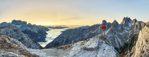 Hiker admiring the Dolomites at sunrise in front of Cadini di Misurina, Auronzo di Cadore