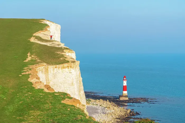 Framed Print : Hiker with arms raised stands on top of the white and chulky cliff overlooking Beachy Head lighthouse, Seven Sisters Country Park, South Downs National Park, Sussex, England, United Kingdom Framed Print : Hiker with arms raised stands on top of the white and chulky cliff overlooking Beachy Head lighthouse, Seven Sisters Country Park, South Downs National Park, Sussex, England, United Kingdom