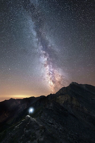 Hiker under the Milky Way at Agnello Pass, Valle Varaita, Piedmont, Italy
