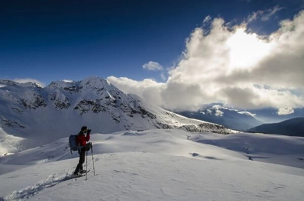 An hiker its photographing the winter landscape (Val d Ayas, Vallee d Aoste)