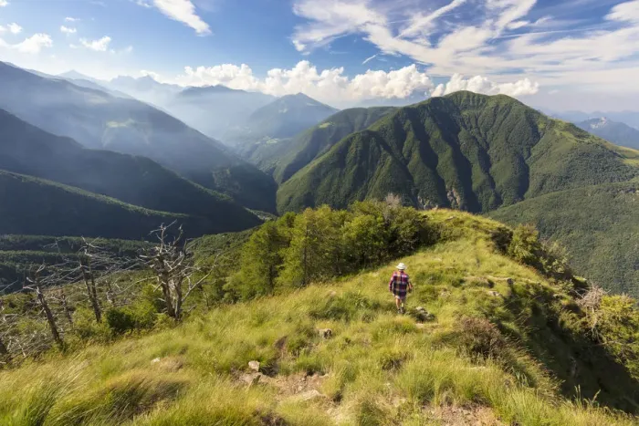 Framed Print : Hiker walks on Monte Legnoncino with Valvarrone and Valsassina in the background Framed Print : Hiker walks on Monte Legnoncino with Valvarrone and Valsassina in the background