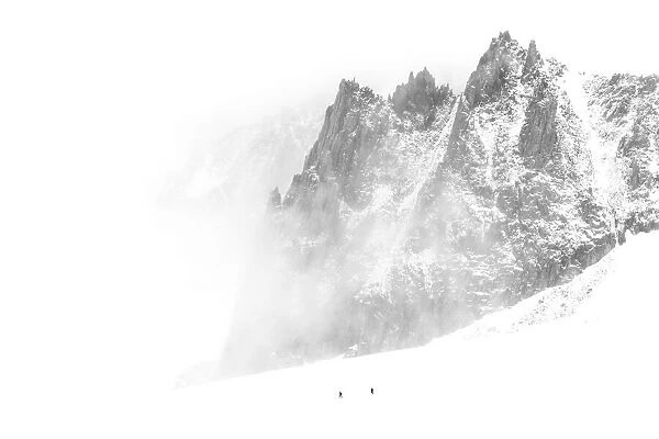 Two hikers making their way back to the Torino Hut (on the Mont Blanc) during a windy summer day