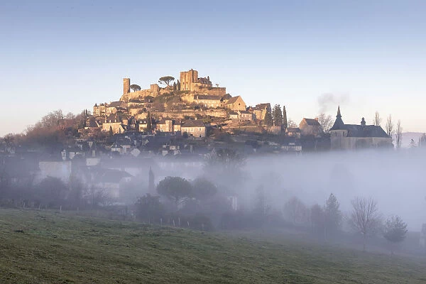 Hilltop village of Turenne surrounded by mist, Correze; Nouvelle-Aquitaine; France