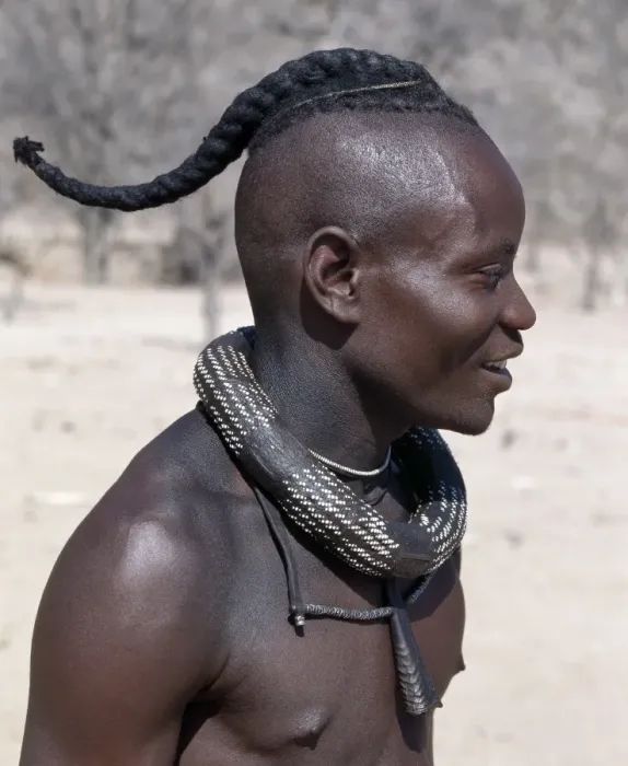 Framed Print : A Himba youth has his hair styled in a long plait, known as ondatu Framed Print : A Himba youth has his hair styled in a long plait, known as ondatu