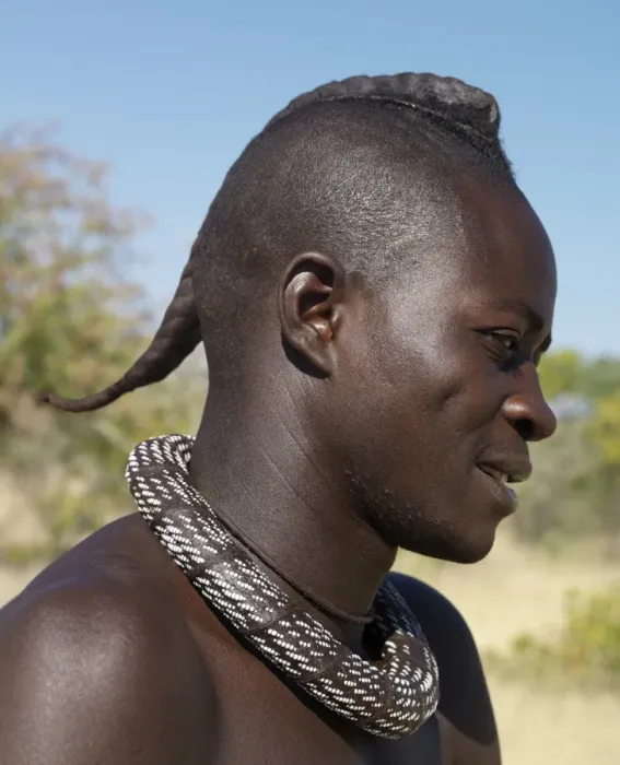 Framed Print : A Himba youth with his hair styled in a long plait, known as ondatu