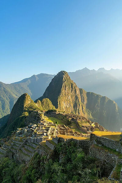Historic ancient archeological Incan Machu Picchu on mountain in Andes at sunrise, Cuzco Region, Peru