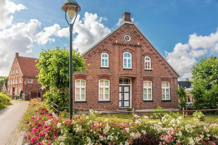 Framed Print : Historic brick house and lush floral decorations in the village of Rysum, Krummhoern, East Frisia, Lower Saxony, Germany Framed Print : Historic brick house and lush floral decorations in the village of Rysum, Krummhoern, East Frisia, Lower Saxony, Germany
