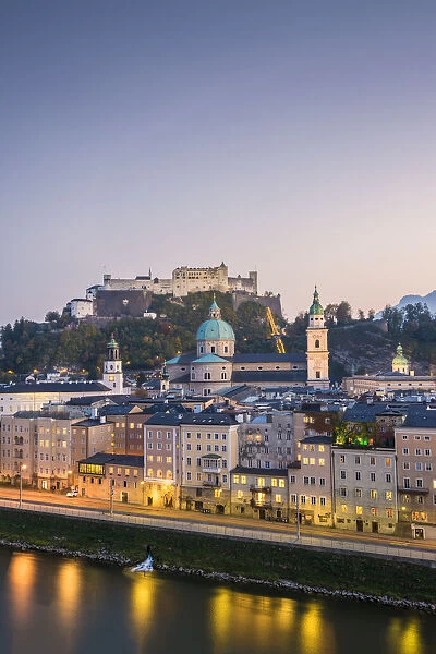 Historical old town of Salzburg reflected in Salzach river at dusk with Hohensalzburg