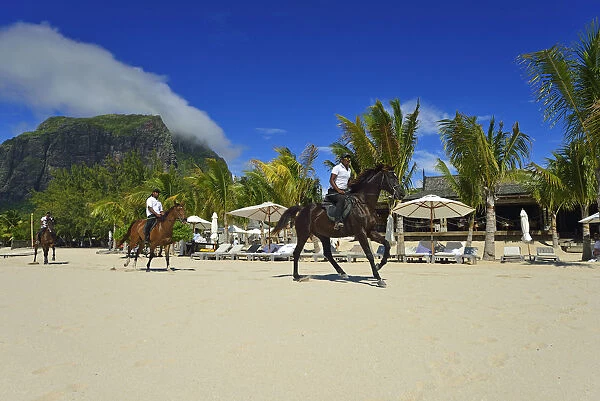 Horse riders on the beach in front of a luxury hotel on the Le Morne Peninsula