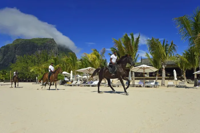 Framed Print : Horse riders on the beach in front of a luxury hotel on the Le Morne Peninsula