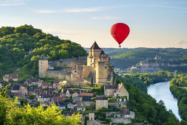 Hot-air balloon over Chateau de Castelnaud castle and Dordogne River valley in late