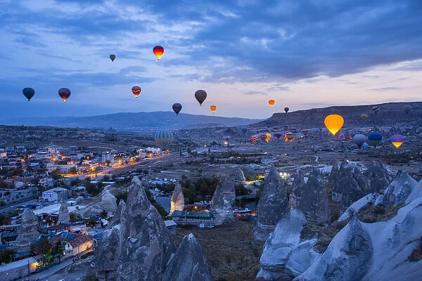 Hot air balloons flying in the blue sky of Goreme at dusk