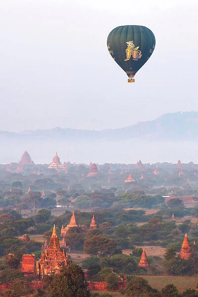 Hot air baloon flying at sunrise over the Bagan Valley archaeological area temples, Old Bagan, Mandalay Region, Myanmar. Bagan was declared a UNESCO World Heritage Site in 2019