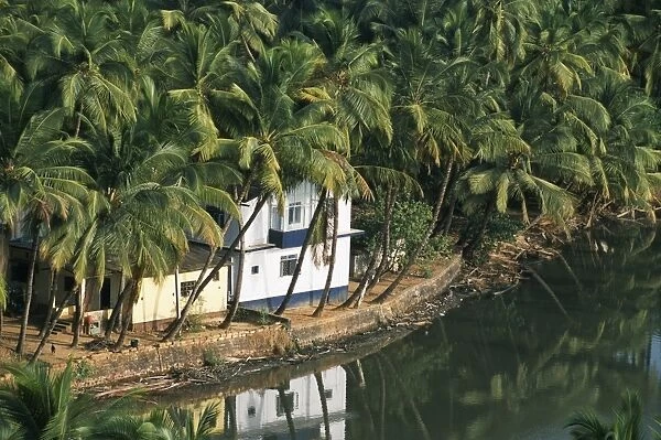 A house looks out on a palm-fringed lagoon