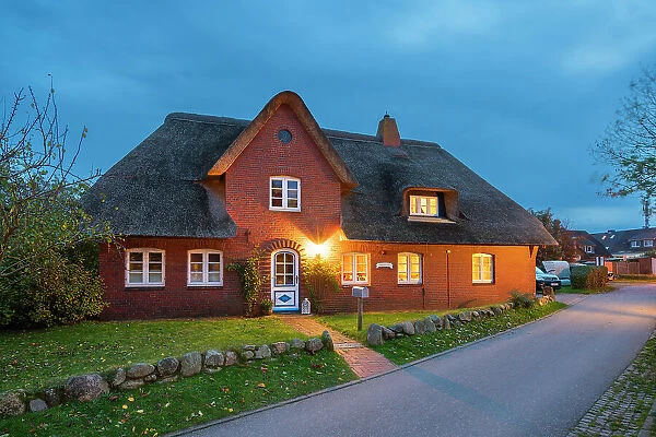 House with traditional thatched roof at twilight, Nebel, Amrum island, Nordfriesland, Schleswig-Holstein, Germany