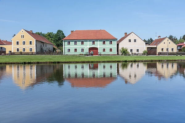 Houses in the historical village of Holasovice reflected in the Roubaicek pond