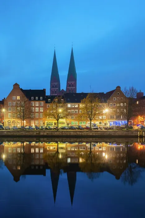 Framed Print : Houses on riverfront of Trave river with towers of St. Marienkirche church in background at twilight, Lubeck, UNESCO, Schleswig-Holstein, Germany