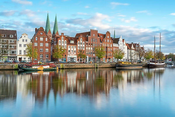 Houses on riverfront of Trave river with towers of St. Marienkirche church in background, Lubeck, UNESCO, Schleswig-Holstein, Germany